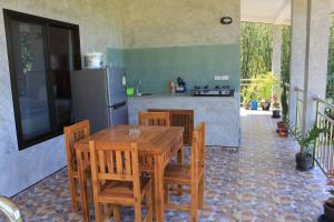a kitchen with a table and chairs and a refrigerator at Nananuira Apartment and Room in Khao Lak