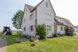 a white house with a truck parked in the yard at Ferienhaus S`bunde Heisle in Blaufelden