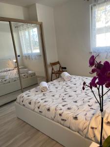a bedroom with a large bed and a mirror at Appartamento Iris in Mori