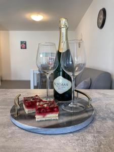 a tray with two glasses and a bottle of wine at Appartamento Iris in Mori