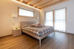 a bedroom with a bed and two windows at Chalet Sant'Antoni Plan in Livigno