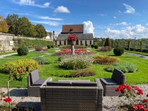 a garden with wicker furniture and flowers in front of a house at Apartment Remise in Langenburg