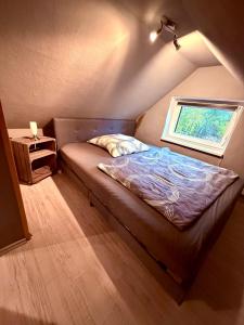 a small bed in a room with a window at Alte Schmiede in Melzow