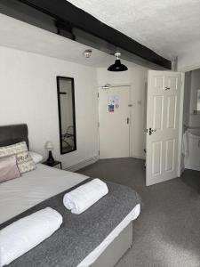 a bedroom with two beds and a door with a mirror at The Britannia Inn in Sherborne +4 photos