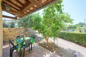 a table and chairs on a patio with a tree at Podere Chinco - Gavorrano in Gavorrano