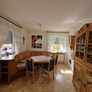 a dining room with a table and a cross on the wall at Ferienwohnung Mawitha in Roth