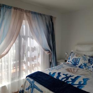 un dormitorio con una cama y una ventana en Dunes Alcove, en Mossel Bay