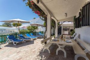 eine Terrasse mit einem Tisch, Stühlen und Sonnenschirmen in der Unterkunft Villa Morena in Albufeira