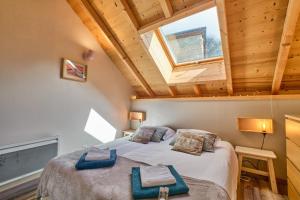 Un dormitorio con una cama grande con ventana. en Duplex Sauna privé Vénosc Le 1618, en Les Deux Alpes