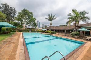 a swimming pool with a city skyline in the background at Taarifa Suites by Dunhill Serviced Apartments in Nairobi