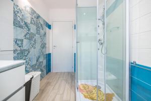 a bathroom with a shower with a glass door at Ibiscus Rosa 1 in Geremeas +16 photos