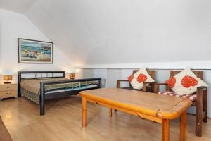 a bedroom with a bed and a bench and a table at Wohnen Im Grünen in Hamburg