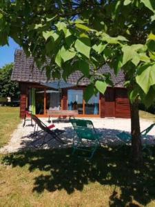 a chair and a bench in front of a house at Mon petit coin de paradis in Darazac