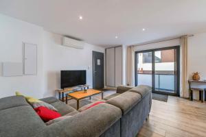 アクス・レ・テルムにあるAux pieds des pistes - Appt Aのソファとテレビのあるリビングルーム