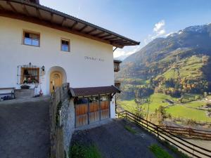 un gran edificio blanco con vistas a la montaña en Strickerhof - Appartment 2, en Saltusio