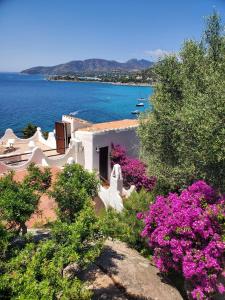 a house with a view of the water and flowers at Villa Renata Torre delle Stelle in Torre delle Stelle