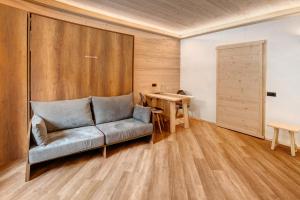 a living room with a couch and a wooden wall at Appartamento Centro Santa Caterina in Santa Caterina Valfurva