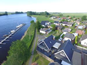 - une vue aérienne sur un village au bord de la rivière dans l'établissement Ferienhaus Martje, à Hennstedt