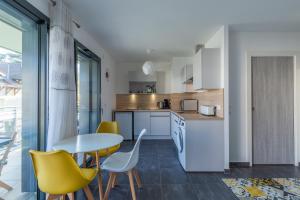 サン・ジョリオにあるGrand studio bord du lacのテーブルと椅子のあるキッチンとダイニングルーム +13枚の写真