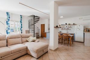 a living room with a couch and a kitchen at Villetta Elena in Alcamo