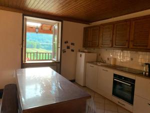 eine Küche mit einem weißen Kühlschrank und einem Fenster in der Unterkunft Gîte À La Ferme Au Puy Mary in Mandailles