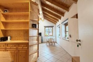 a kitchen with wooden cabinets and a table and chairs at NEU! Ferienwohnung Durach in Durach