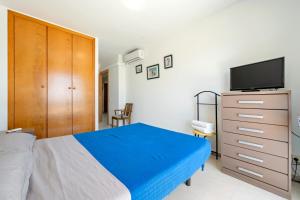 トラダンバーラにあるVistas al mar Torredembarraのベッドルーム(ベッド1台、ドレッサー、テレビ付)
