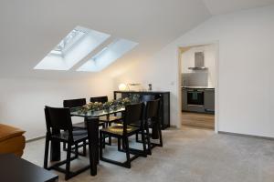 une salle à manger avec une table et des chaises noires dans l'établissement Modernes Appartement 100m2, à Wustermark