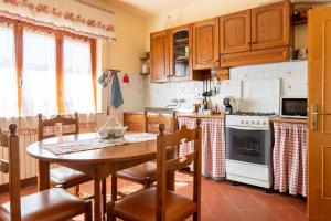 Una cocina con gabinetes de madera y una mesa con sillas. en Casa Vacanza Lola, en Castiglion Fiorentino