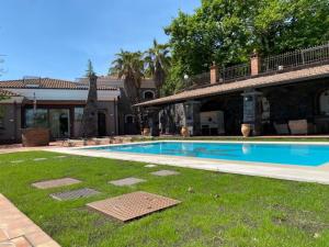 a swimming pool in a yard next to a house at Casa Carlotta in Zafferana Etnea