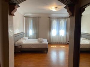 a bedroom with two beds and two windows at Casa Carlotta in Zafferana Etnea +23 photos