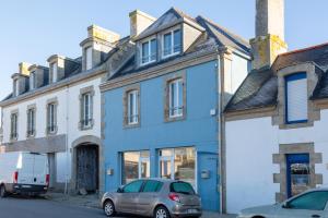 a blue house with a van parked in front of it at Appartement de charme in Le Guilvinec