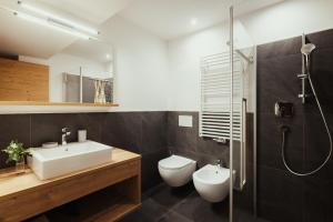 a bathroom with a sink and a toilet and a shower at Chalet La Flüta Viola in La Valle