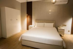 une chambre avec un grand lit blanc dans une pièce dans l'établissement شاليه البرادايس 26 في درة العروس, à Durat Alarous