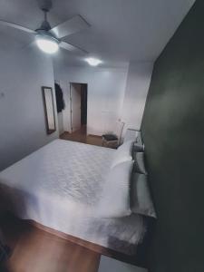 a bedroom with a white bed and a ceiling fan at Apartamento Alegria in Garrucha