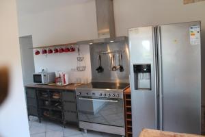 a kitchen with a stove and a refrigerator at Les Ecuries in Saint-Maurice-en-Cotentin