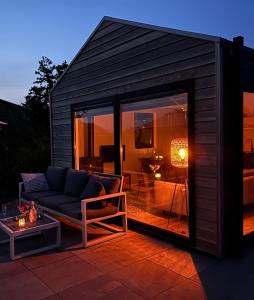 ein Haus mit einem Sofa und einer Terrasse in der Unterkunft Marina Strandbad Chalet Wellness Hideaway Haus Nr 402 in Olburgen