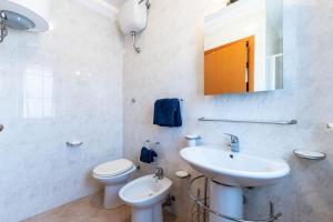 a bathroom with a sink and a toilet and a mirror at Appartamenti Cavour Codice E in Villasimius