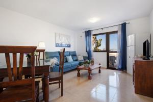 un salon avec un canapé bleu et une table dans l'établissement La Casa De Los Sueños, à Corralejo