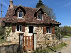 una antigua casa de ladrillo con una puerta de madera en Gite et Spa Chez Marguerite, en Angoisse