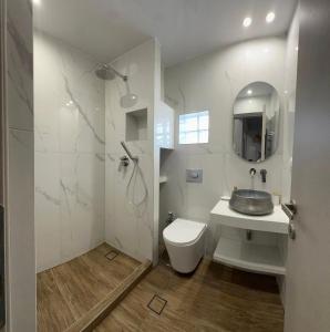 a white bathroom with a sink and a toilet at Avres Apartments in Skiathos Town