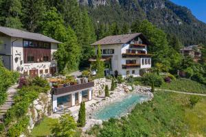 een huis op een heuvel naast een rivier bij Baumannhof Mooskofel - adults only in Plazzoles