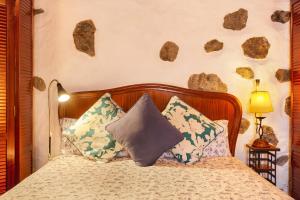 a bedroom with a bed with rocks on the wall at Casita Roque Nublo in Tejeda