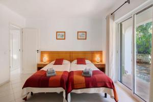 a bedroom with a large bed with red and orange blankets at Villa Rose in Albufeira +26 photos