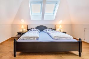 a bedroom with a bed with two night stands and two windows at Alpen Living - 2 Stock in Cadipietra +19 photos