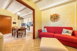 a living room with a red couch and a table at Luxury Apartment Simius in Villasimius