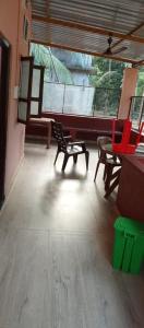 a room with two chairs and a piano at Lewis Paradise Homestay in Kalyānpur