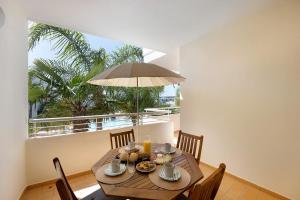 a dining room with a table and a large window at Villa Mós - Beach Apartments in Lagos