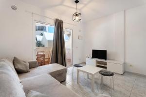 een woonkamer met een bank en een tv bij Apartamento El Médano Marineda in Granadilla de Abona