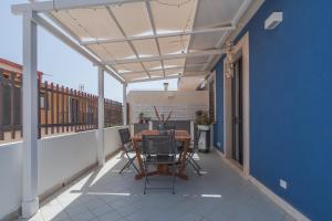 eine Terrasse mit Tisch und Stühlen auf einem Balkon in der Unterkunft Andromeda Luxury Home in Portopalo